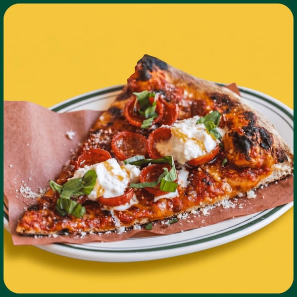 A single slice of pizza with pepperoni, burrata, basil, and parmesan on a white plate.